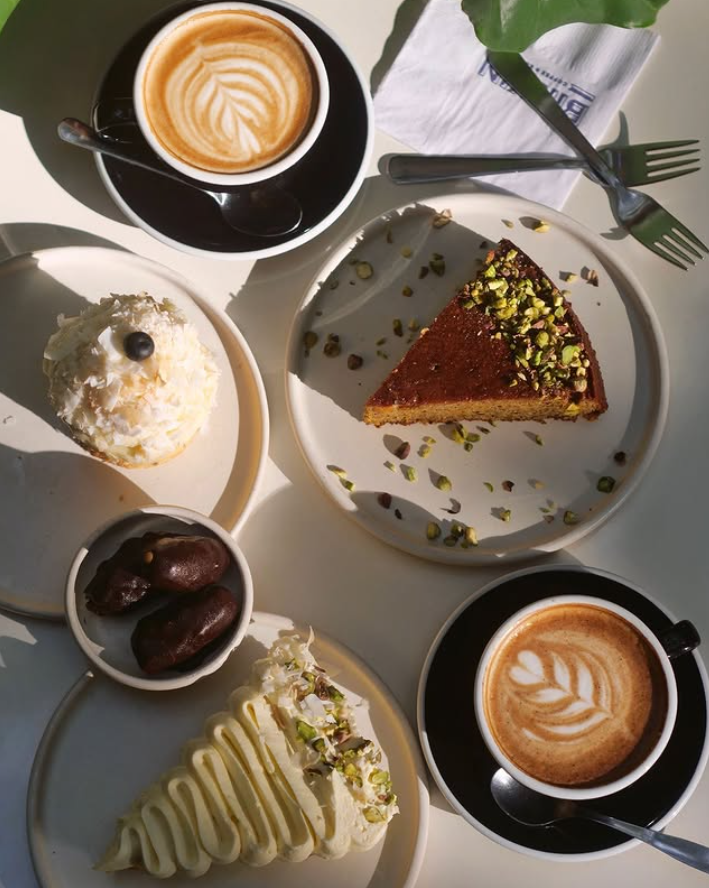 Tartas, postres y dos cappuccinos sobre la mesa