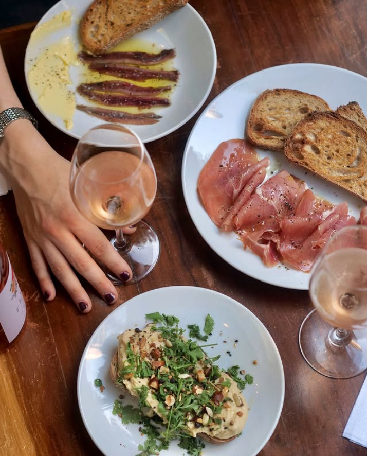 Vinos, jamón crudo y brindis en la mesa